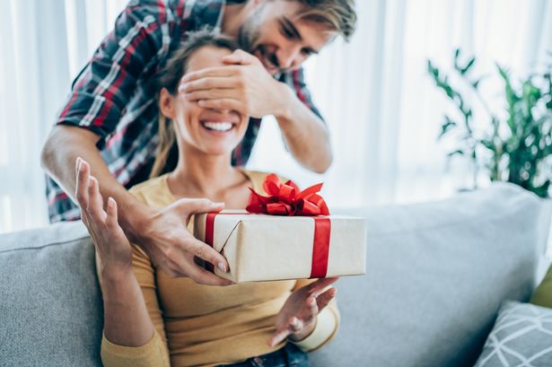 0 Cheerful young woman receiving a gift from her boyfriend Y0BtQr